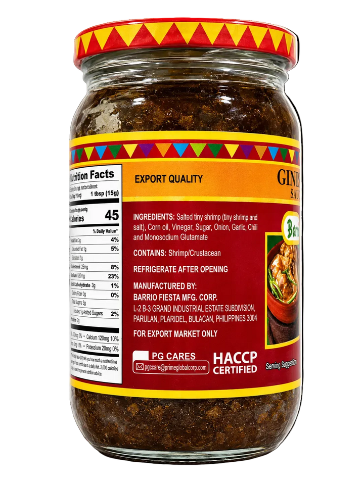 A glass jar of Gini's Shrimp Salty condiment with a red and yellow patterned lid, showing the export quality label and ingredients of salted tiny shrimp.