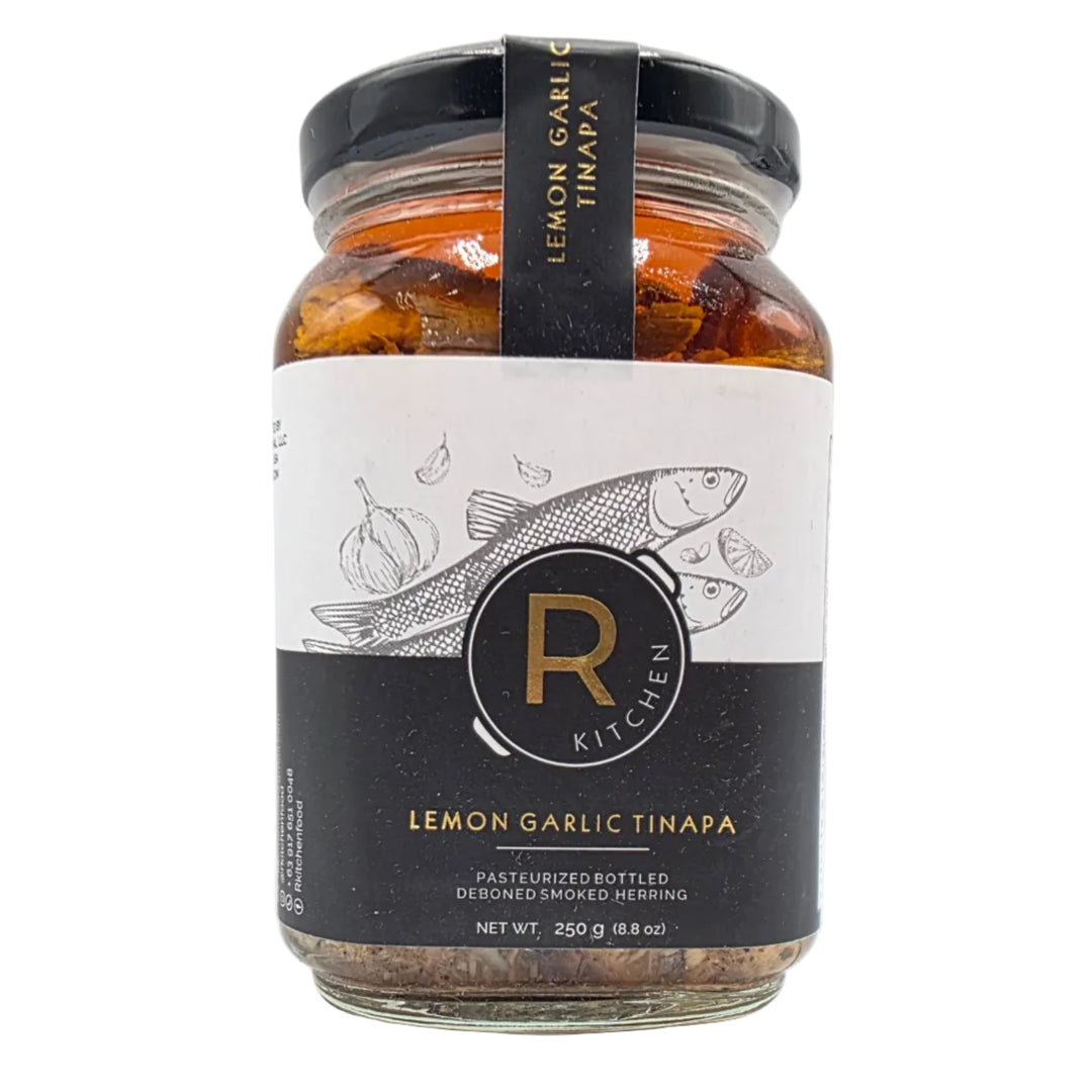Jar of lemon garlic timbaal with a black label on a white background