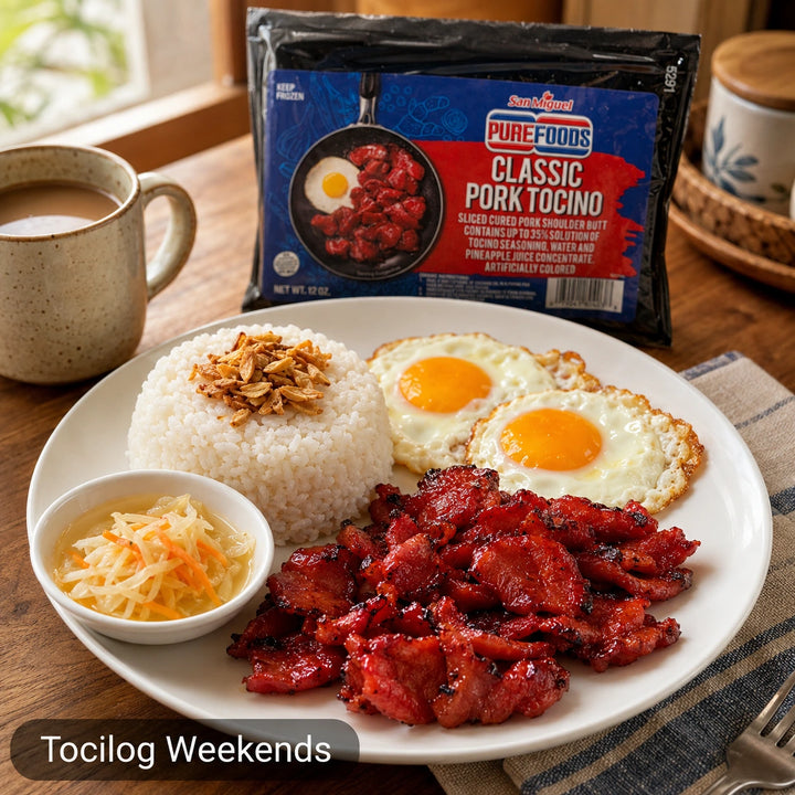 A plated breakfast featuring cooked pork tocino, white rice, fried eggs, and a small bowl of pickled vegetables, with a package of Purefoods Classic Pork Tocino standing behind the plate on a wooden table. A mug and kitchen setting are visible, and a text overlay reads 'Tocilog Weekends'.