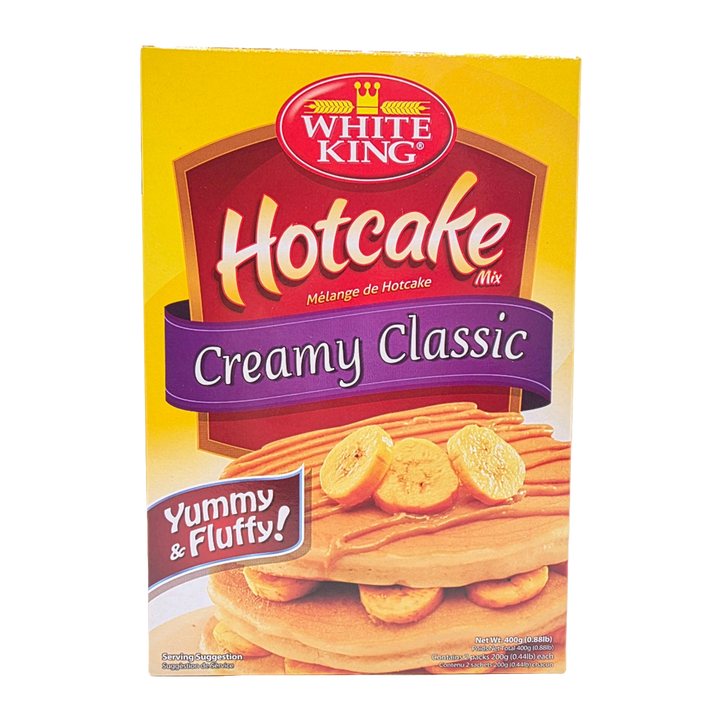 White King Hotcake Mix Creamy Classic box, featuring a yellow background with a red and purple logo banner and an image of banana pancakes on the front.